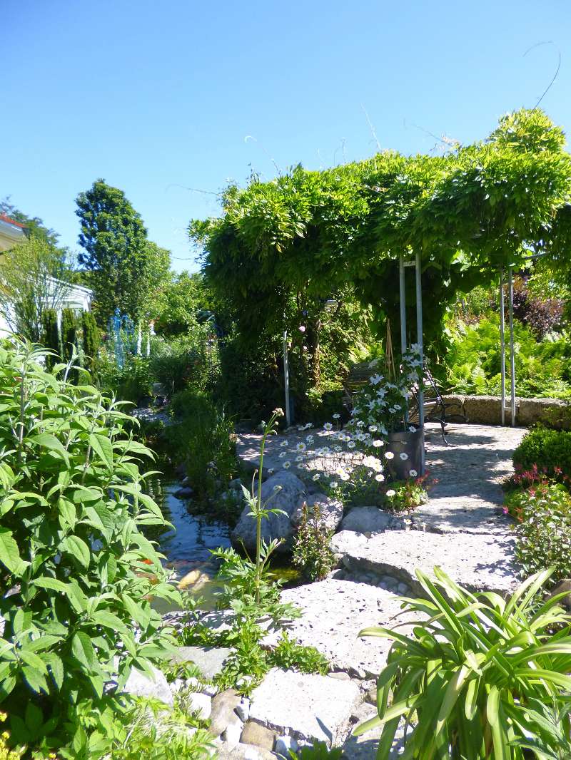 Erholungsbereich mit Teich Schöner, schattiger Erholungsbereich an einem Teich in einem Privatgarten